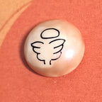 Close-up of Angel mindfulness pebble with wings symbol on supportive affirmation card about healing and strength.