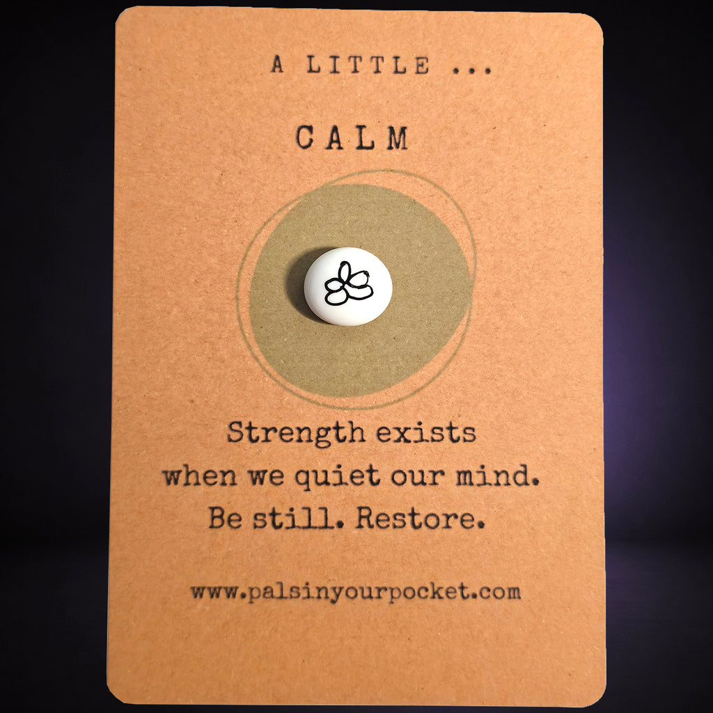 "A Little Calm” mindfulness card with a small white meditation pebble, featuring the message: “Strength exists when we quiet our mind. Be still. Restore."