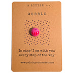 A Little Wobble mindfulness pebble on affirmation card reminding that it is okay to wobble and offering encouragement.