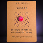 A Little Wobble mindfulness pebble on affirmation card reminding that it is okay to wobble and offering encouragement.