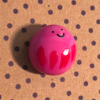 Close-up of Wobble mindfulness pebble with smiling face on supportive affirmation card about staying positive.