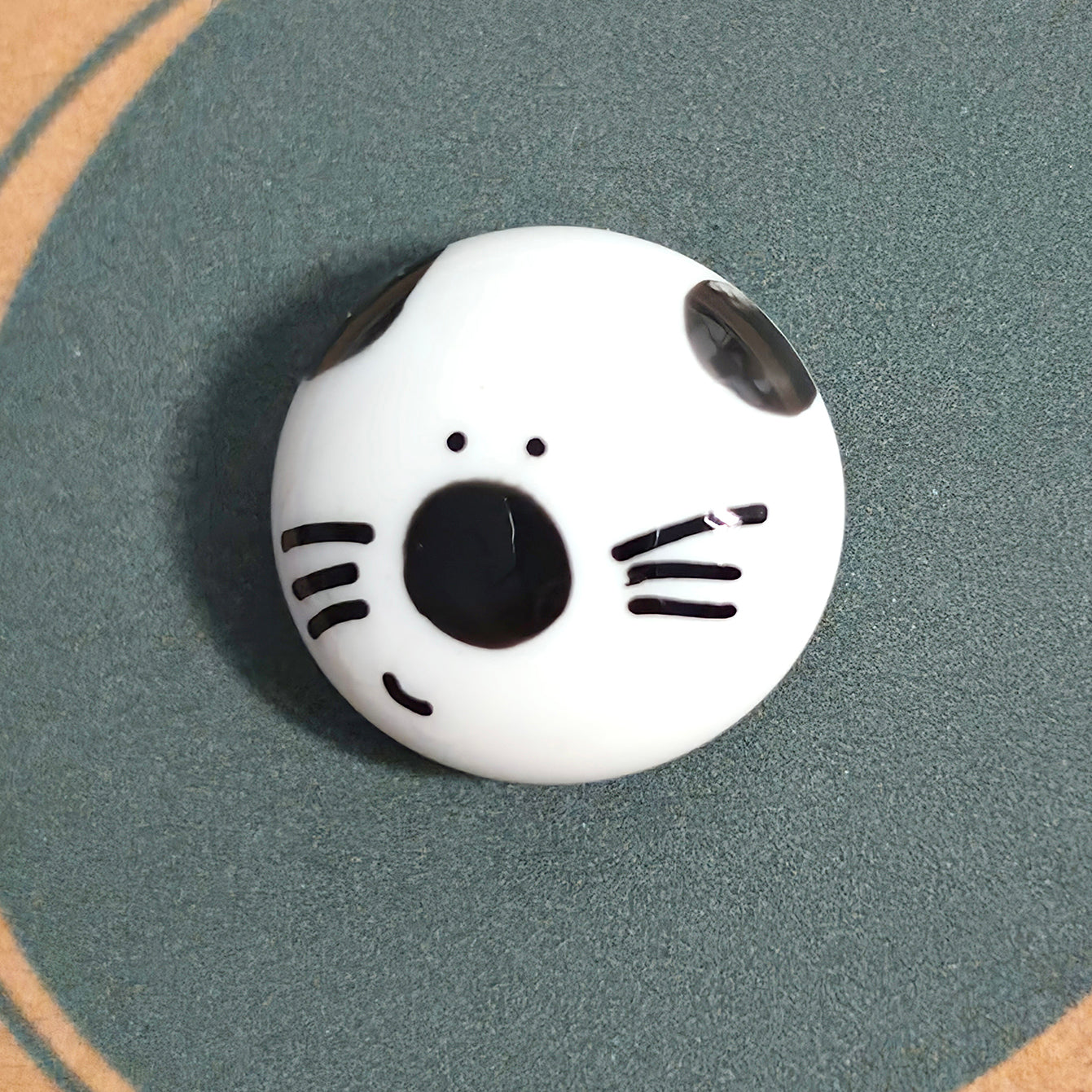 Close-up of Can-Do Cat mindfulness pebble with smiling cat face on encouraging affirmation card.