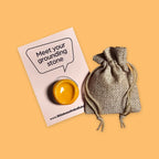 Smooth yellow worry stone with hessian drawstring pouch and 'Meet your grounding stone' information card