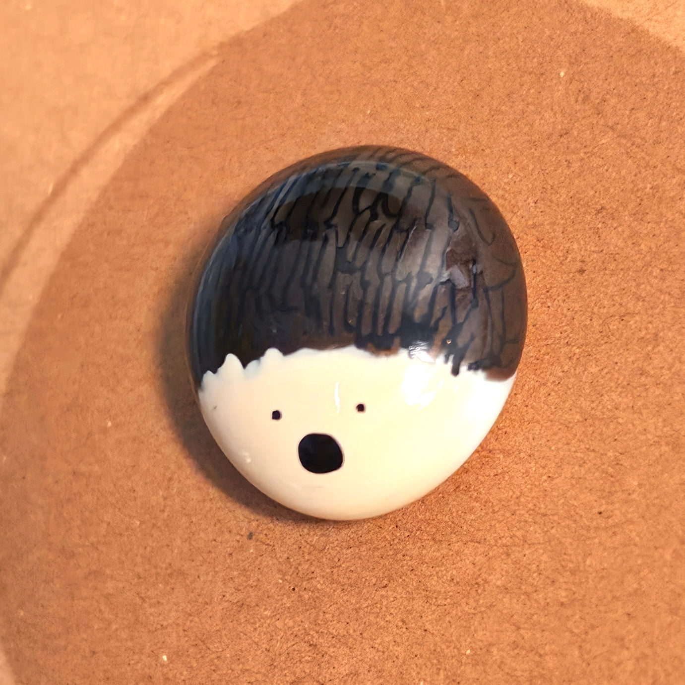 Close-up of Hedge Hug mindfulness pebble with hedgehog face on supportive affirmation card.