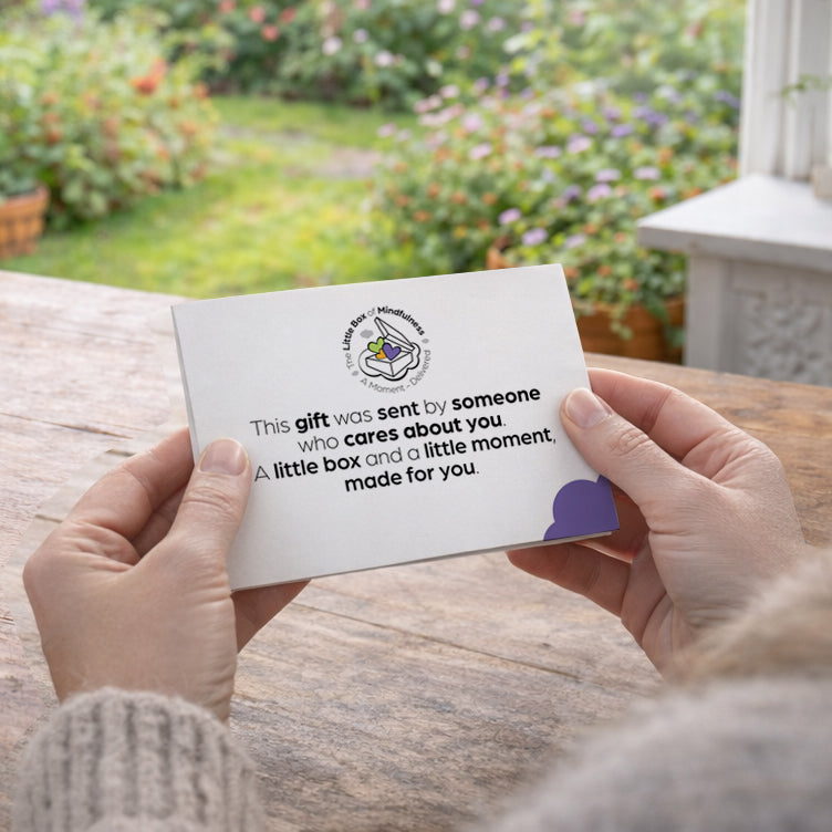 Person holding personalised letter as part of the gift at a kitchen table with a garden view