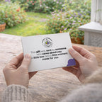 Person holding personalised letter as part of the gift at a kitchen table with a garden view