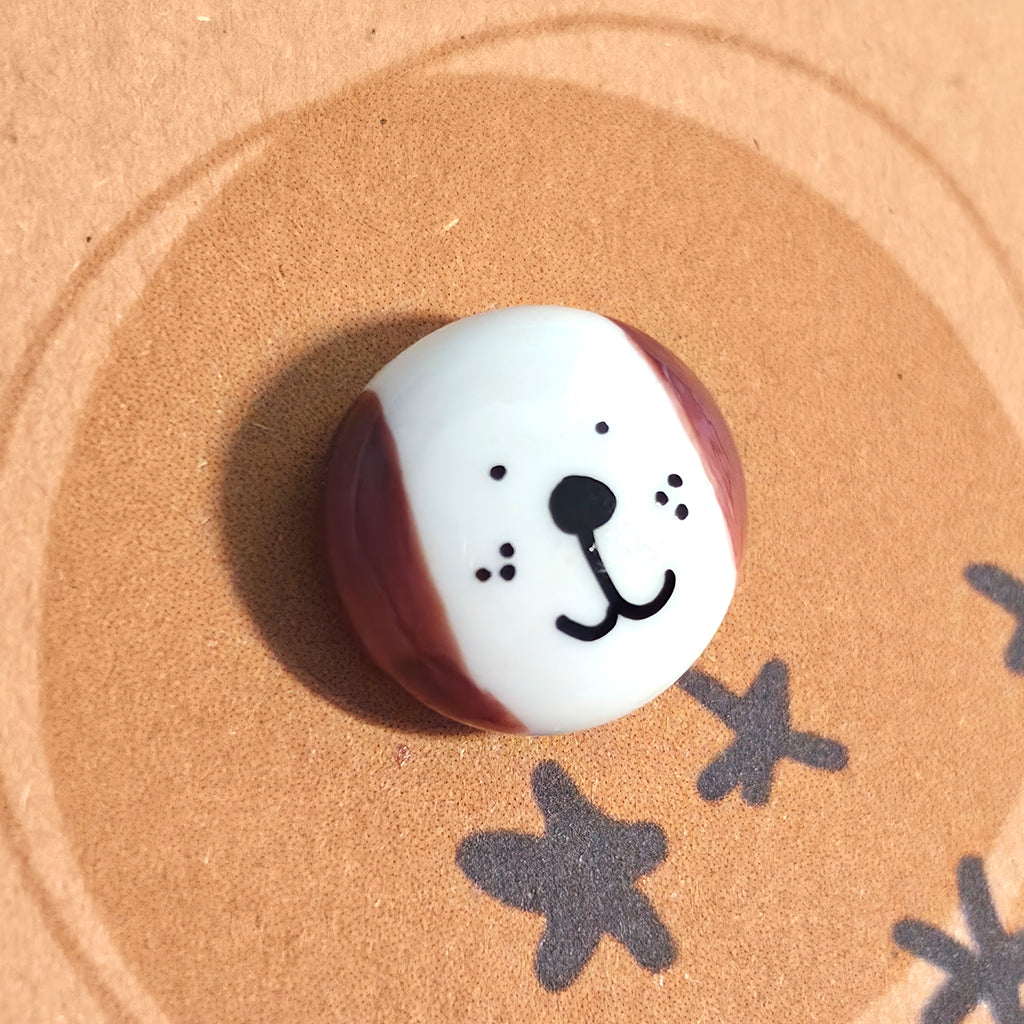 Close-up of Puppy of Positivity mindfulness pebble with smiling dog face on uplifting affirmation card.