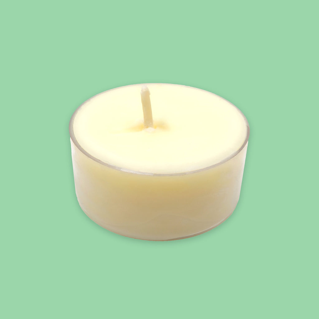 A single cream-coloured soy tea light candle in a clear plastic holder, centred against a solid mint green background.