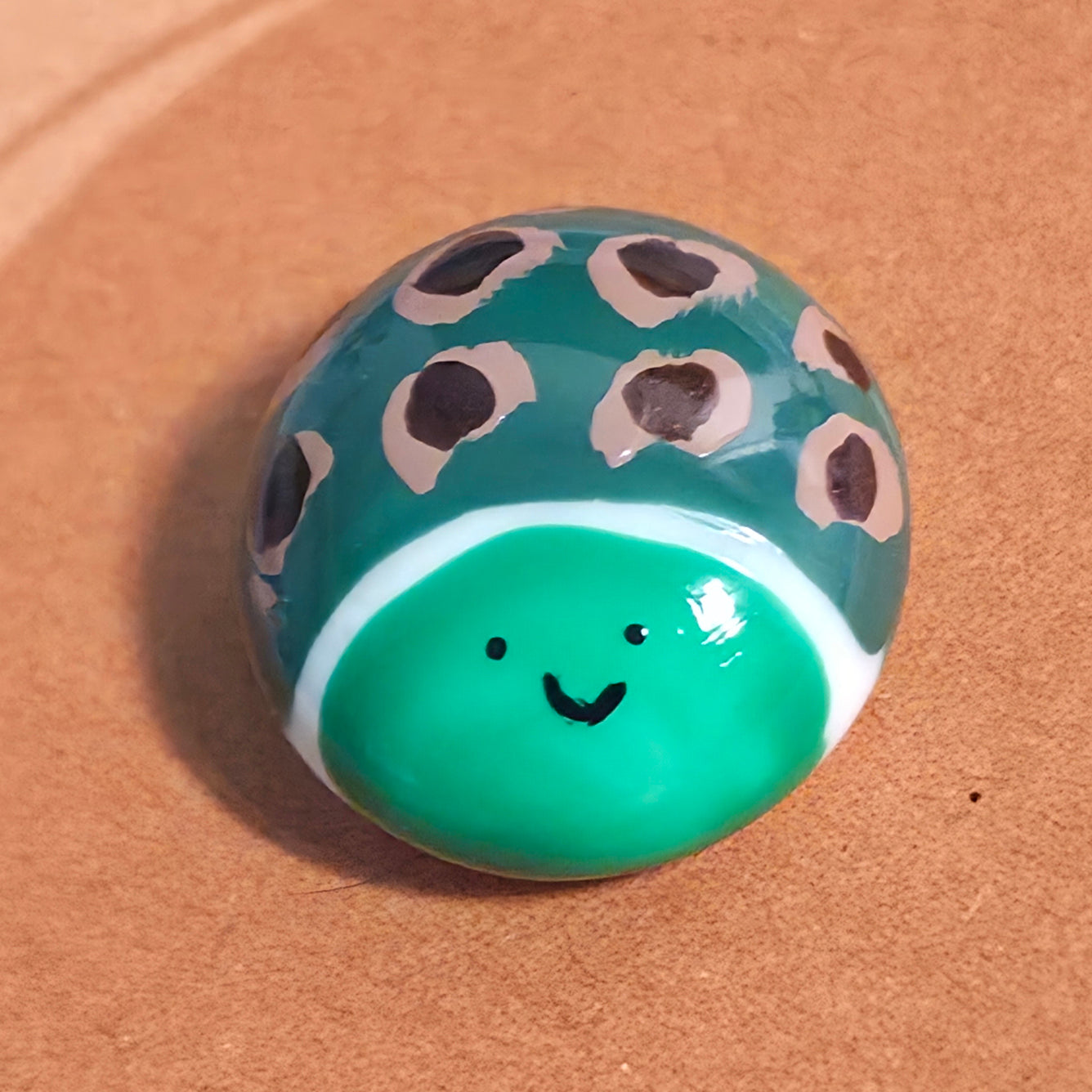Close-up of Step at a Time mindfulness pebble with cute turtle design on motivational affirmation card.