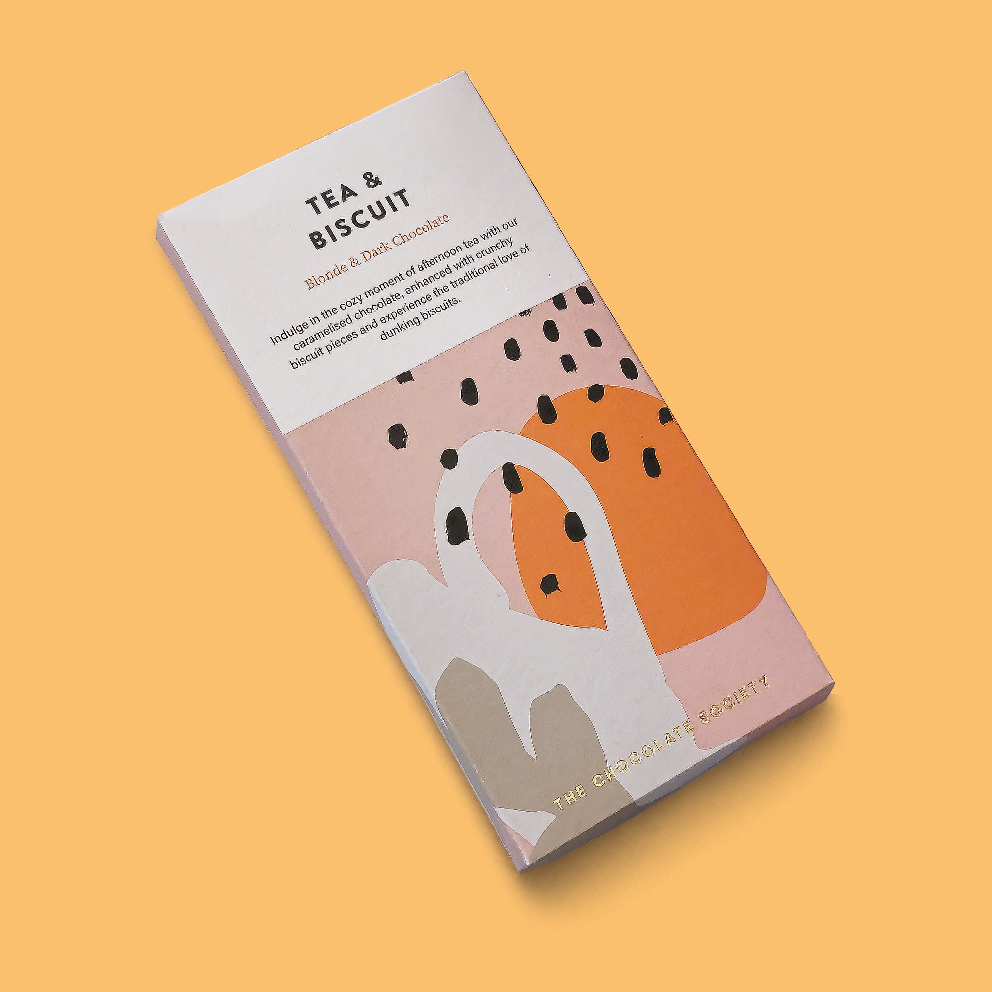 A chocolate bar package labelled 'TEA & BISCUIT' by The Chocolate Society, shown at an angle on a solid warm peach background. The box is mostly white with abstract blush pink, orange, gray, and black shapes, plus small text describing blend 6 dark chocolate.