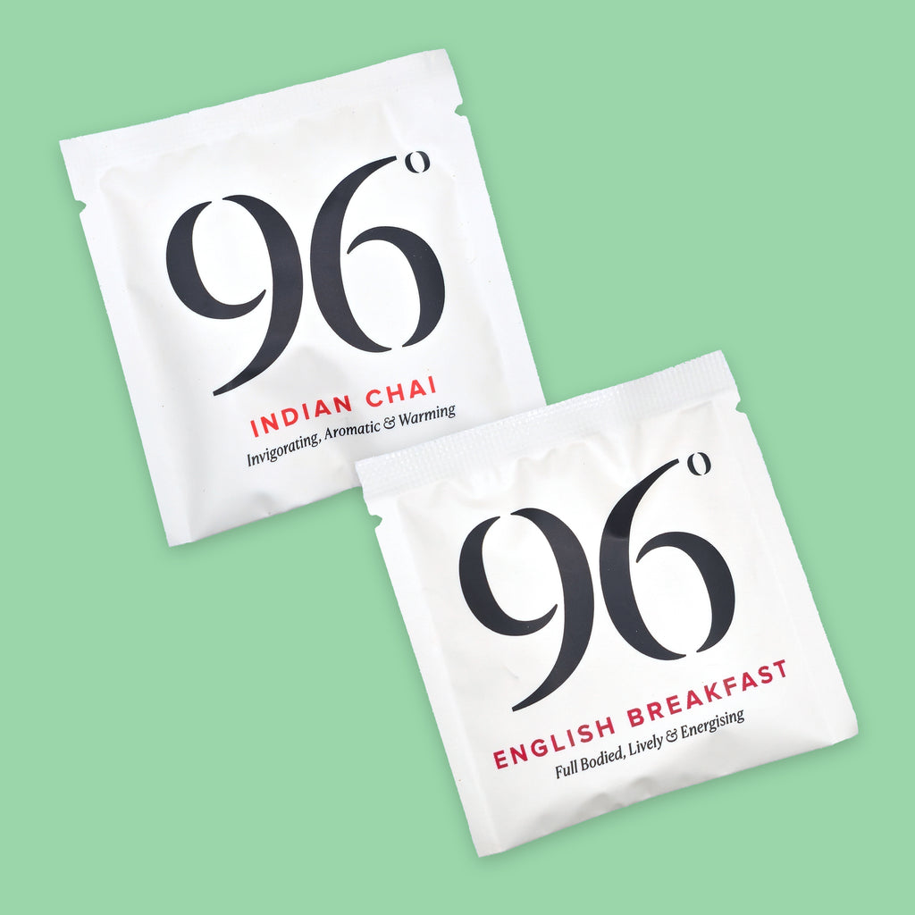 Two white tea sachets from the brand 96, one labeled 'Indian Chai' and the other 'English Breakfast', displayed diagonally on a solid light green background.