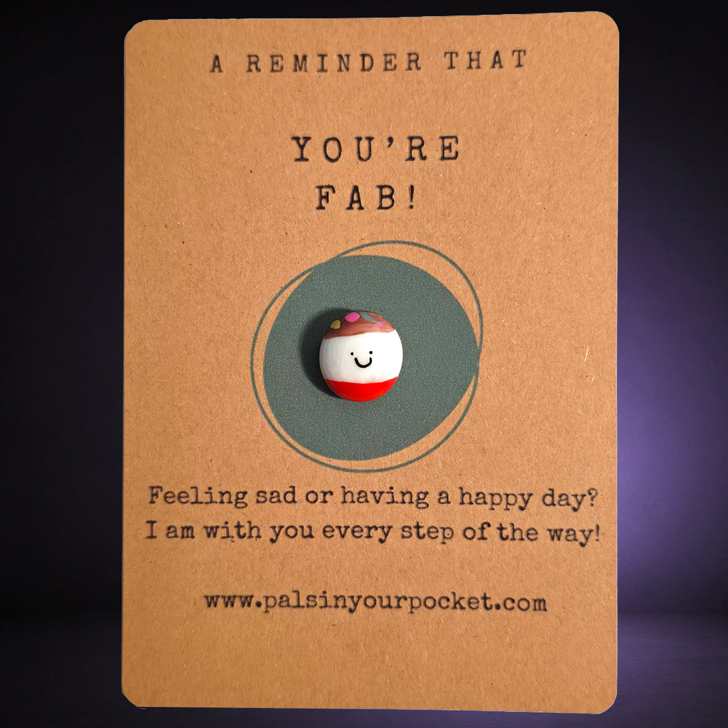 A Reminder That You're Fab mindfulness pebble with smiling face on uplifting affirmation card.